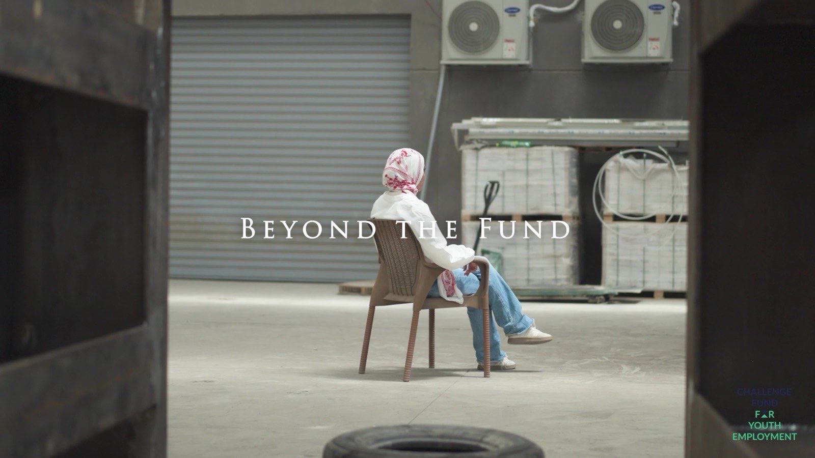 A young woman seated in a large open workspace, with the Beyond the Fund title card over the frame.