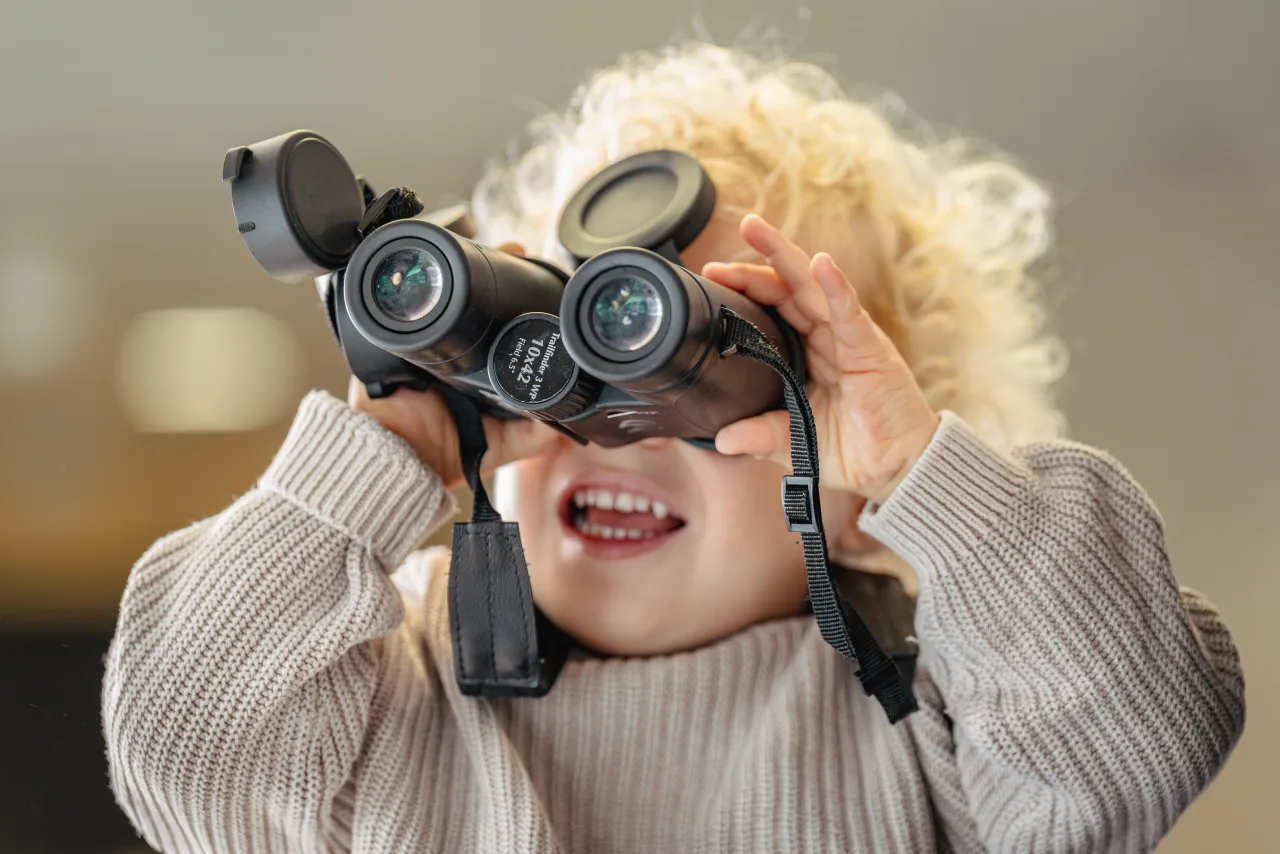 A child looking through a pair of binoculars