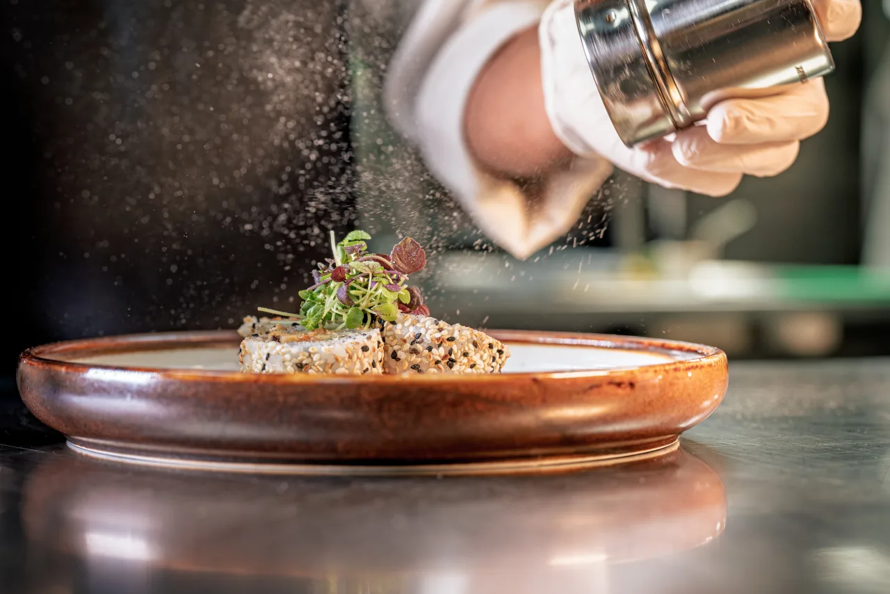 A chef finishing a plated dish