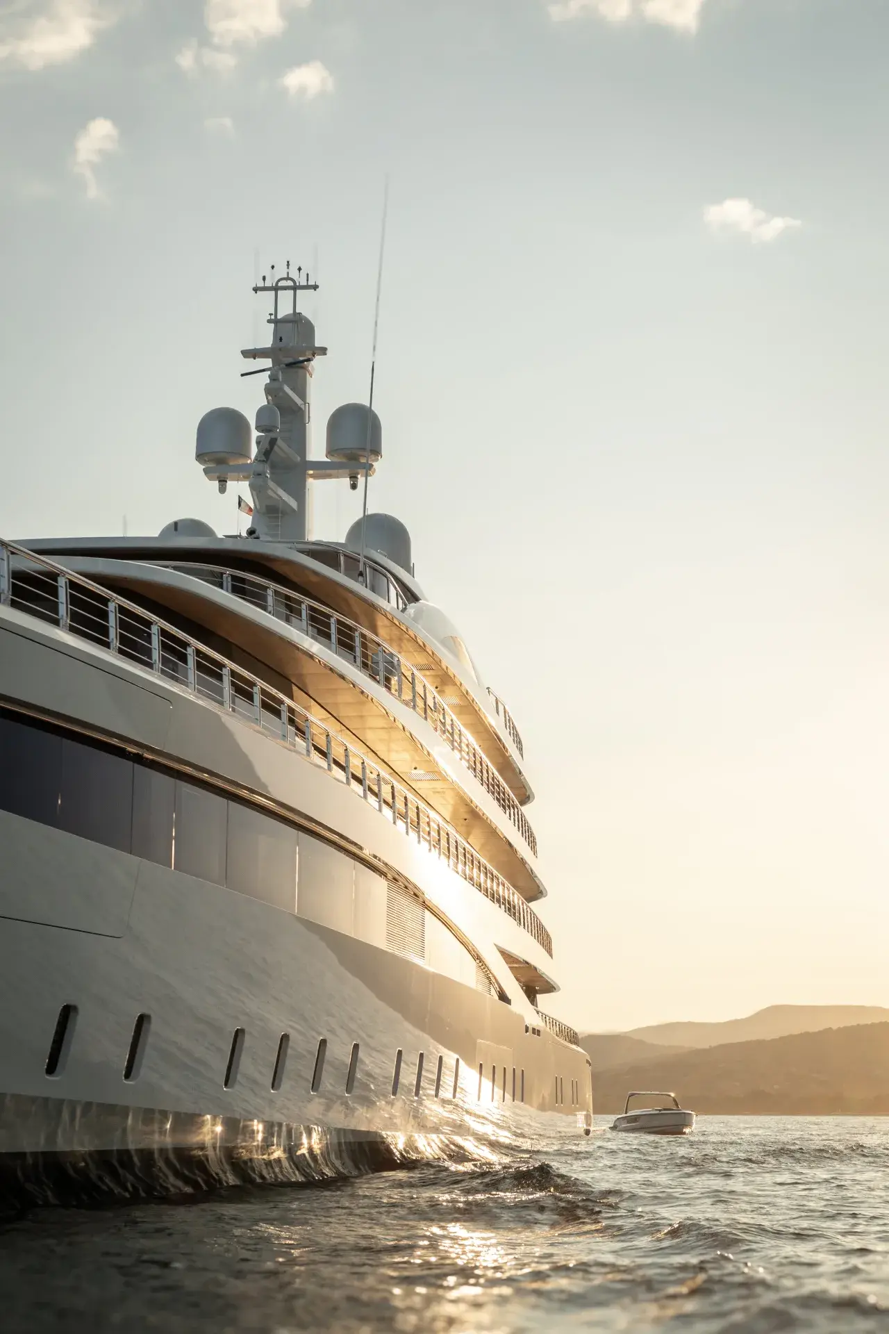 The bow of a superyacht against a pale sky