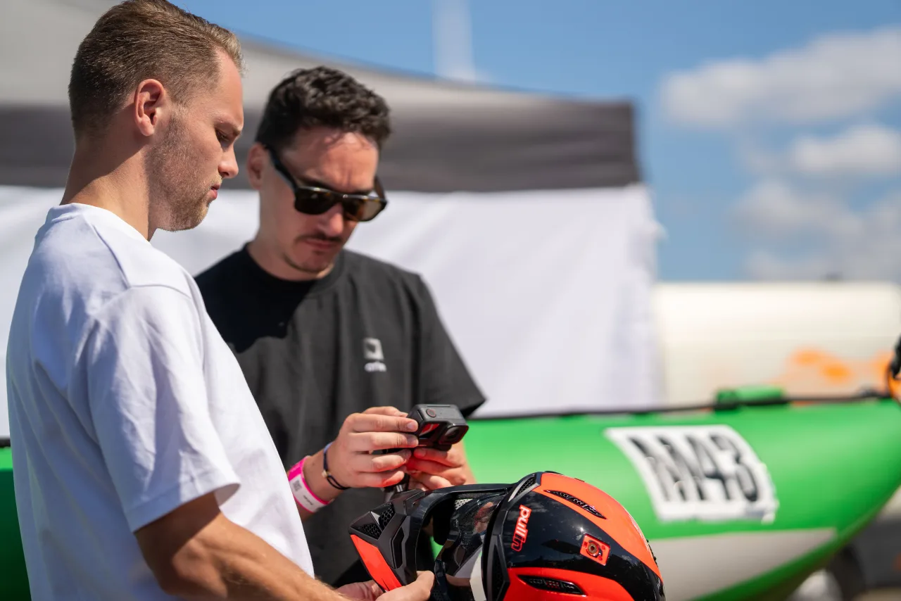 Two crew members reviewing a shot beside a race car