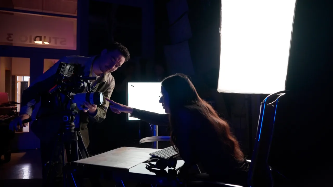 An interview set being lit in a darkened studio