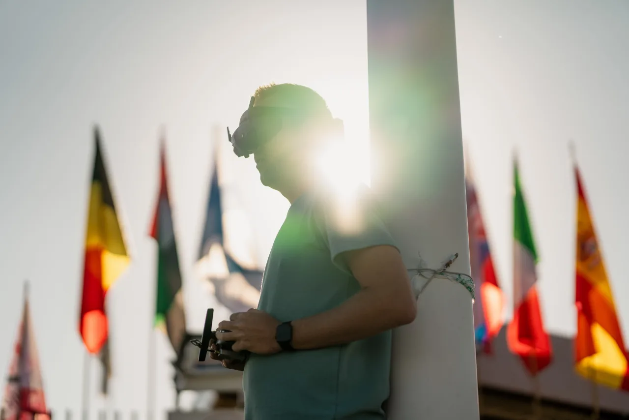 An operator silhouetted against a row of national flags