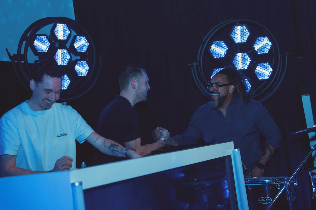 People working at a studio desk under stage lighting